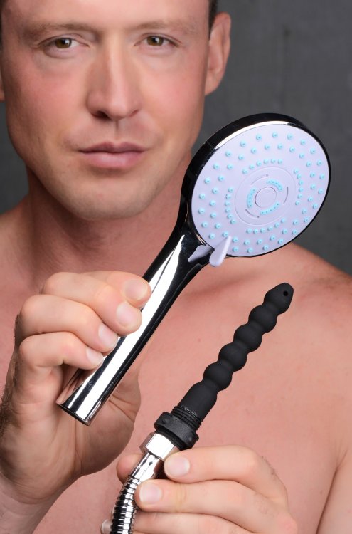 A person smiles at the camera, holding both the shower head and the silicone enema tip towards the camera. | Kinkly Shop
