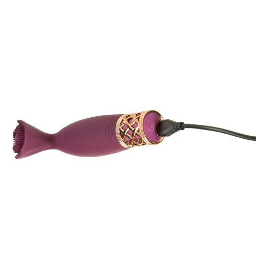 The charging cable plugged into the base of the Pillow Talk Secrets Passion. The power button is illuminated as the vibrator charges. | Kinkly Shop