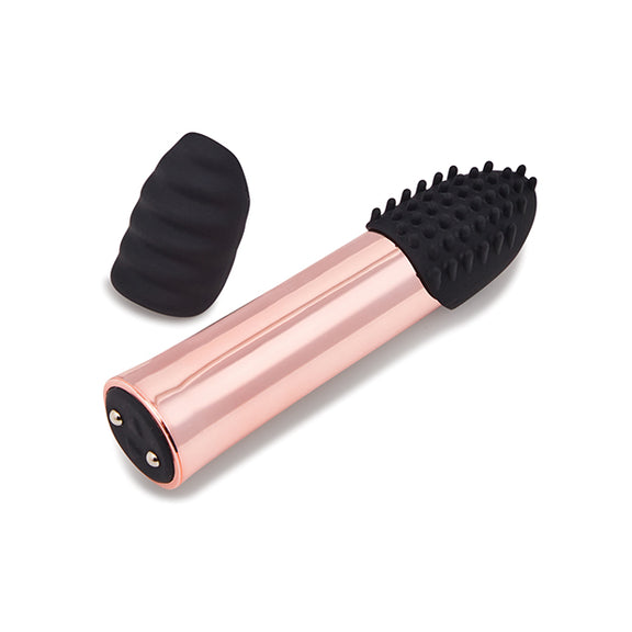 The Point Plus Rechargeable vibrator laying on its side next to one of the extra tips for the tip of the vibe. | Kinkly Shop