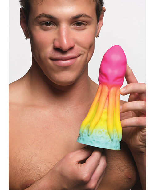 A person holds the Creature Cocks King Kraken between their hands. It looks like average length but very VERY thick near the base. It has a cute rainbow ombre color. | Kinkly Shop