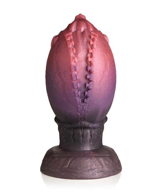 The Creature Cocks Dragon Hatch sits in front of a plain white background. It looks like it has a zipper through the center of the plug where the egg is "hatching". | Kinkly Shop