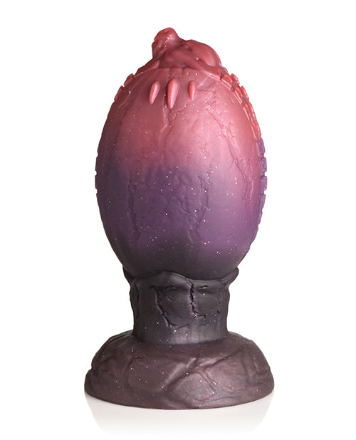 Backside of the Creature Cocks Dragon Hatch showcasing the little dragon's head poking out of the egg as their claws "go through" the flat surface of the egg on this side. | Kinkly Shop