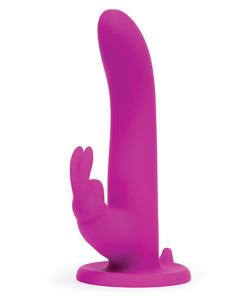 The Happy Rabbit Strap On Harness Set shown sitting out without the harness. It has a large, flared suction cup base with a completely smooth shaft. | Kinkly Shop