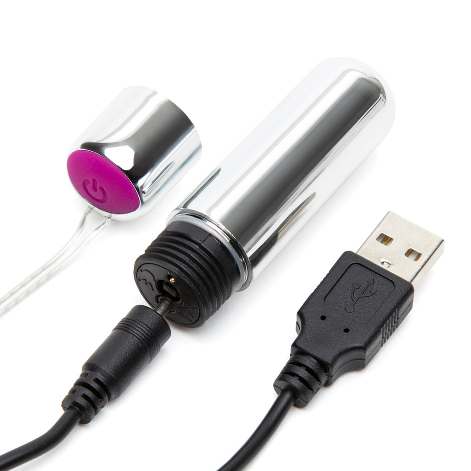 The Happy Rabbit Remote Control Ring bullet vibrator shown with the "lid" of the vibrator removed. This exposes the charging port, and the charger is plugged into the vibrator, showcasing how the bullet charges. | Kinkly Shop