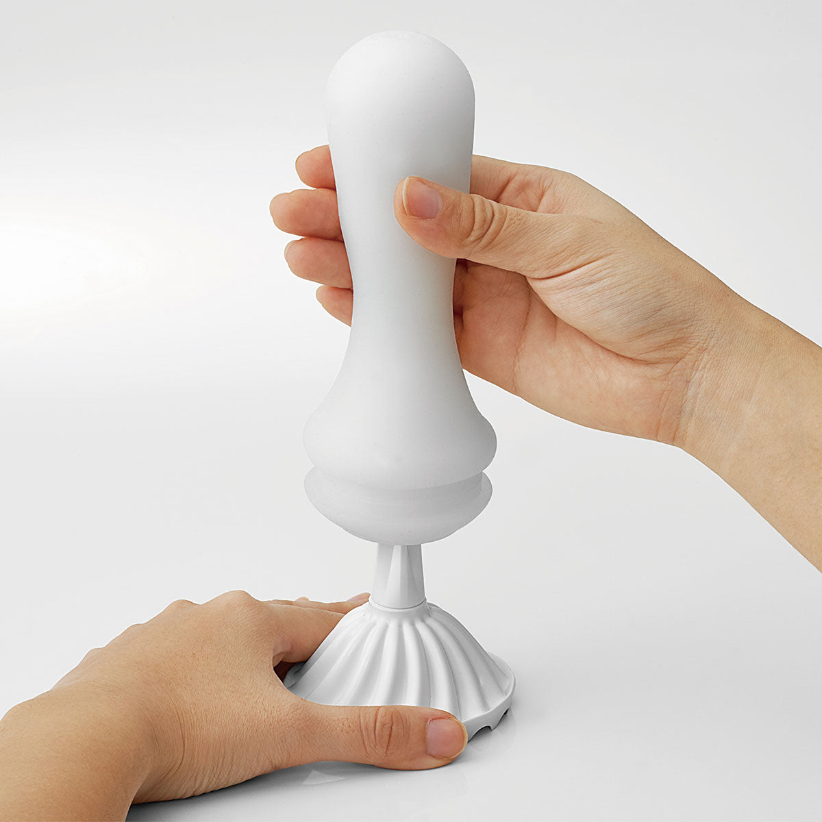 Two hands place the TENGA Flex TPE interior onto the lid that doubles as a drying stand. | Kinkly Shop