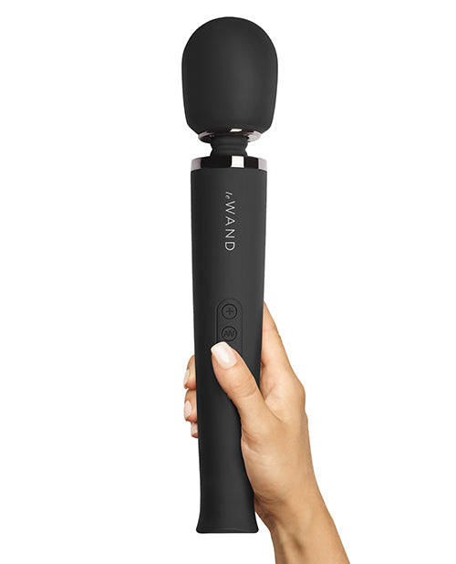 A hand holds the Le Wand Rechargeable Wand in Black against a plain white background | Kinkly Shop