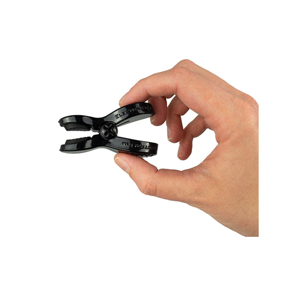 Two fingers hold the ElectraStim Bipolar ElectraClamp, showcasing its large gripping area to make it easier to clamp onto spots. | Kinkly