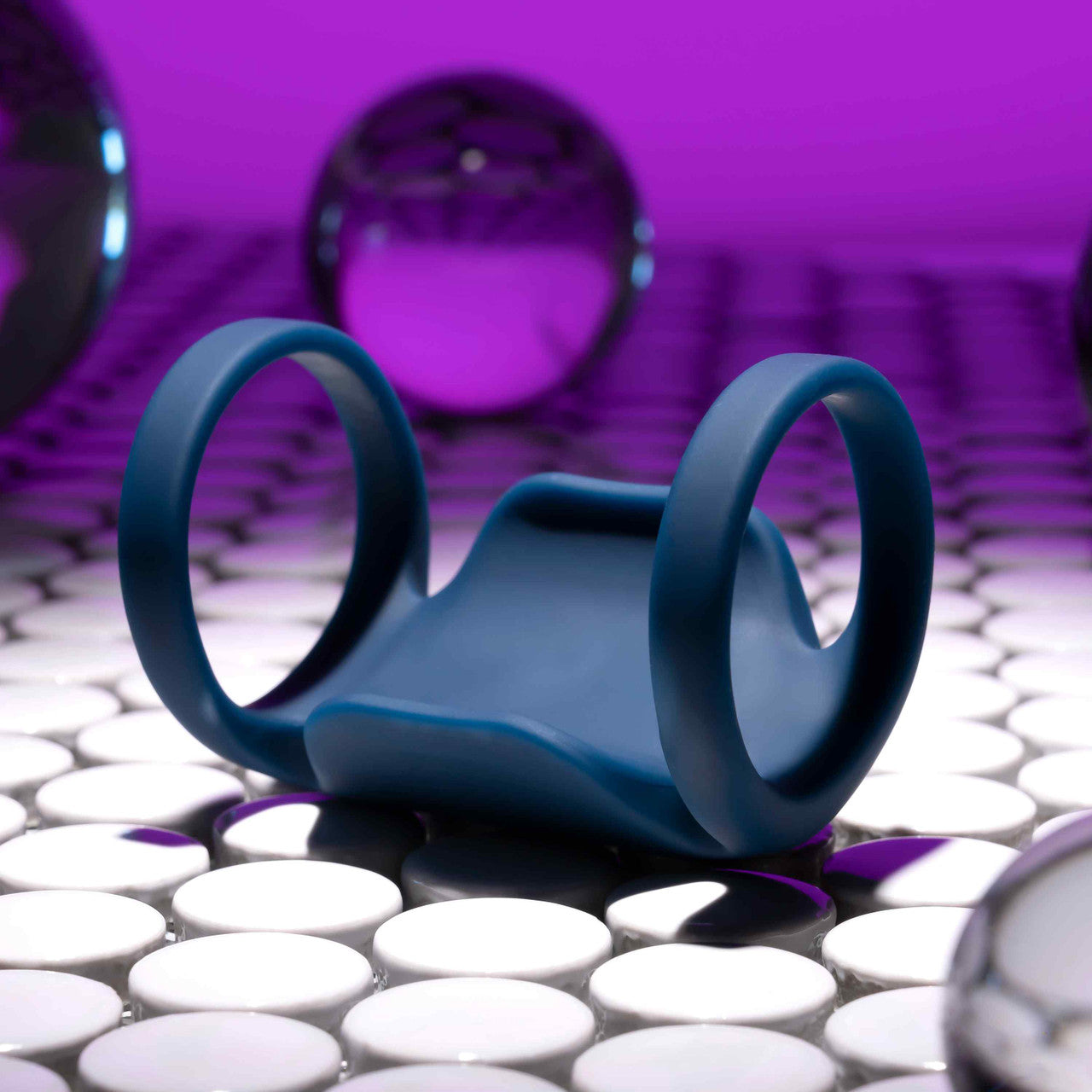 The Playboy Jet Pack lays on a textured surface. The rings look smooth and comfortable and there's no texture on the toy itself. | Kinkly Shop