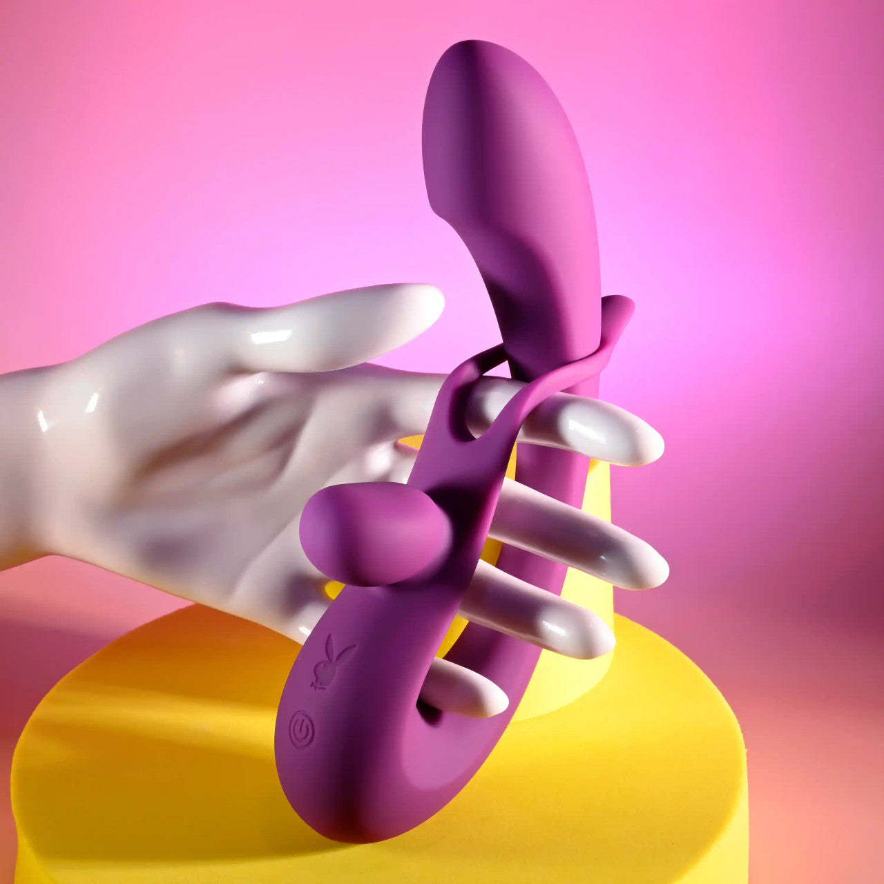 A hand holds the Playboy Cha Cha Slide. The loop of the vibrator also functions as a handle for the toy. | Kinkly