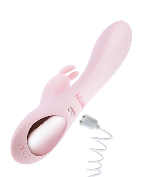 Underside of the Blush Fairy Flutter shown near its charger. The two magnetic charging prongs are on the underside of the vibe. | Kinkly