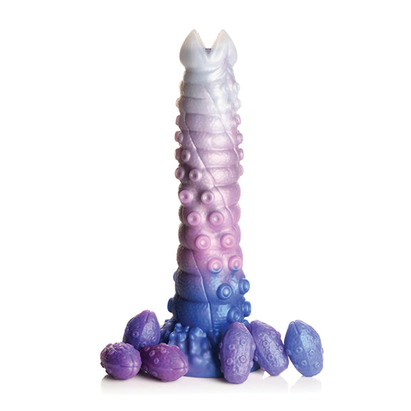 The Creature Cocks Tenta-Queen Ovipositor with all of its included silicone eggs scattered around its base. | Kinkly Shop
