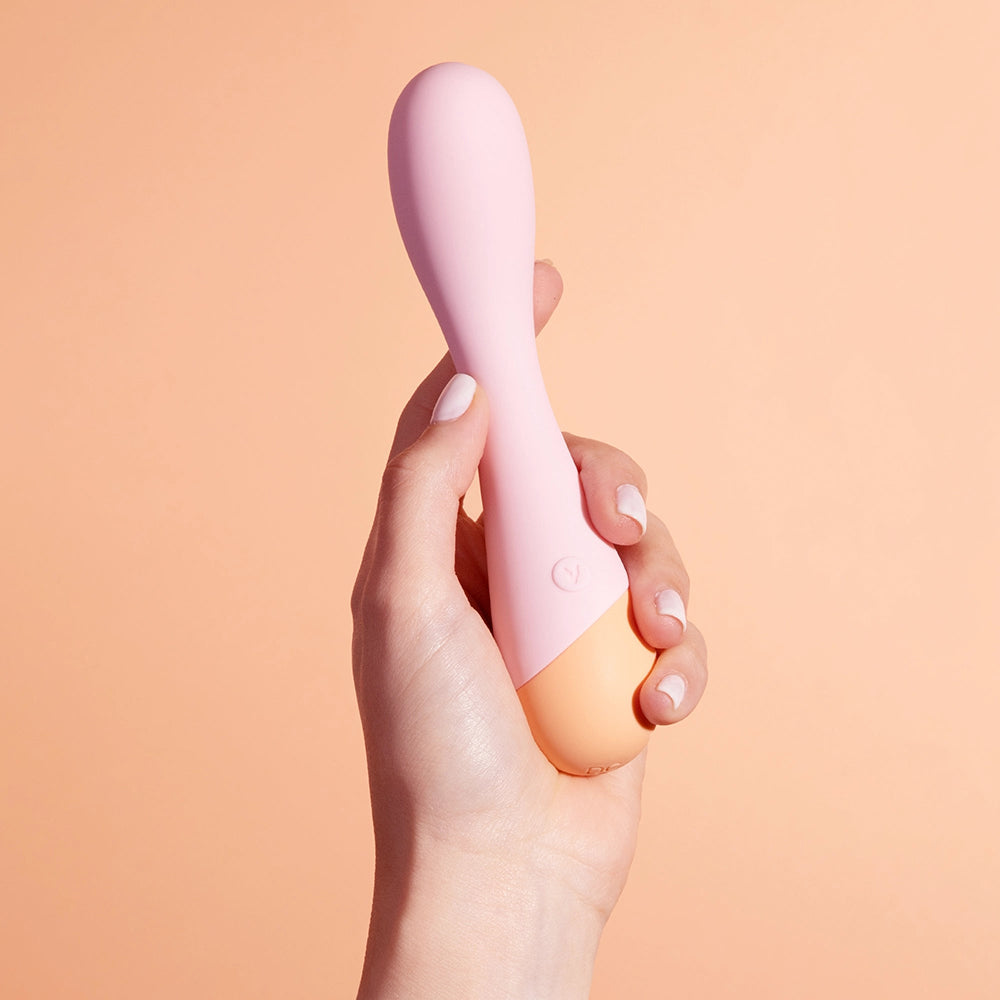 A hand holds the VUSH Peachy G-Spot. The vibrator looks very comfortable in their grip, and the person's fingers wrap around it easily. | Kinkly