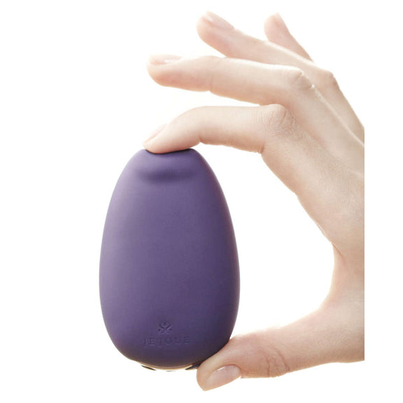 The Je Joue Mimi Soft is held between the pointer finger and the thumb. The material squishes under the pressure, showcasing the super soft material design of the Mimi Soft. | Kinkly