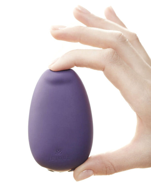 The Je Joue Mimi Soft is held between the pointer finger and the thumb. The material squishes under the pressure, showcasing the super soft material design of the Mimi Soft. | Kinkly