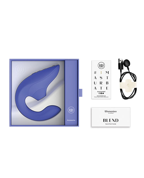 The Womanizer Blend shown next to everything it comes with. There's the charging cable, the toy itself, an iMasturbate sticker, and the instruction booklet. | Kinkly