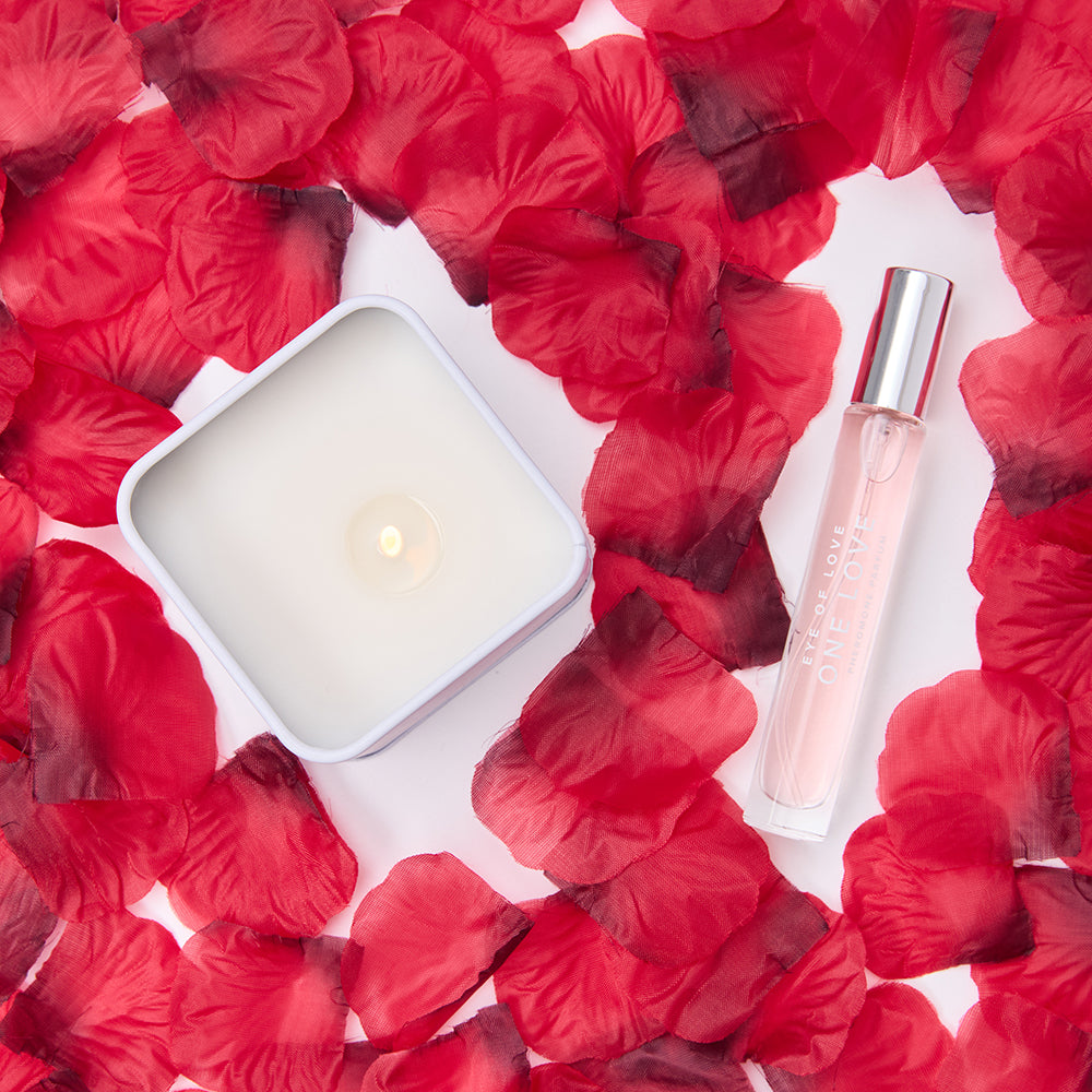 The candle, perfume, and rose petals all together in a single image. | Kinkly