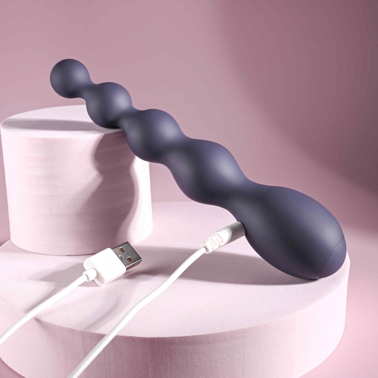 The Zero Tolerance Rumpy Bumpy plugged into the charger that charges it. | Kinkly Shop