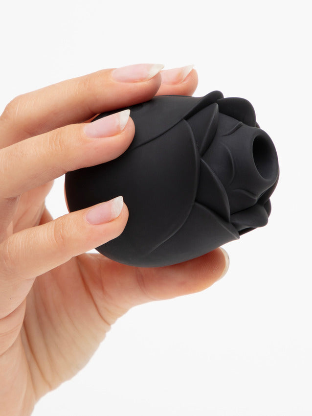 A hand holds the base of the Hearts & Flowers Rose, showing the air suction tip to the camera. The air suction tip protrudes slightly from the rest of the "flower petals" around it. | Kinkly Shop