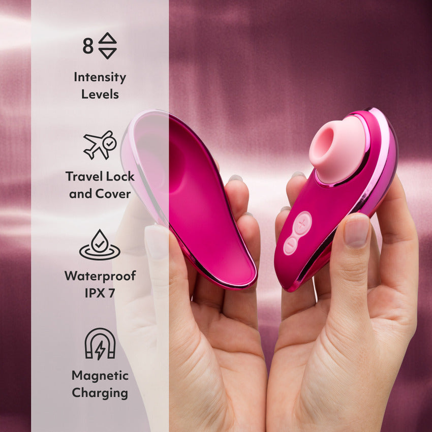 Two hands hold the Womanizer x Iggy Azalea Liberty 2 and its lid. Text on the image reads: "8 intensity levels. Travel lock and cover. Waterproof IPX7. Magnetic charging." | Kinkly Shop