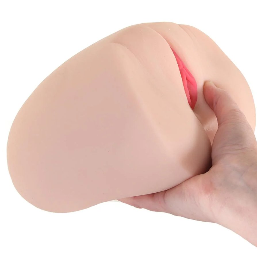 A flat palm is outstretched and holding onto the Angela White Titwoman: Double Sided Masturbator. The stroker is much larger than the person's palm, but it's still small enough to be held by a single hand. | Kinkly Shop