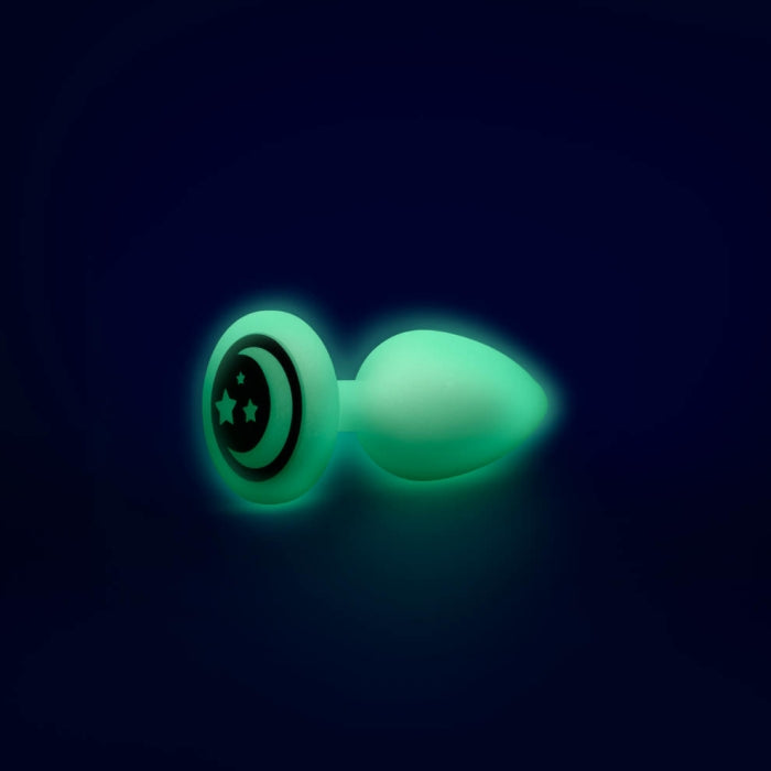 The butt plug lays on its side, showcasing the moon and star design on the base of the plug. | Kinkly Shop