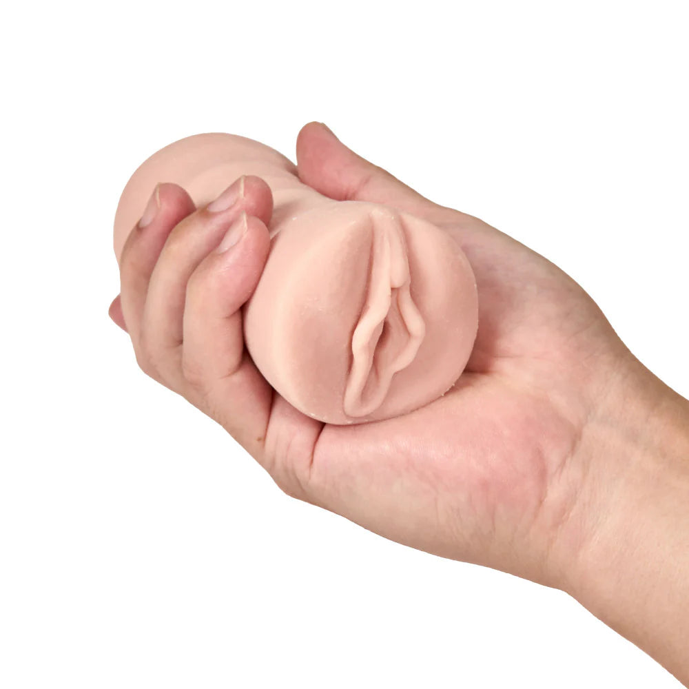 A person holds the Blush Ashley in their hand. The stroker looks like it fits really comfortably in their hand. | Kinkly