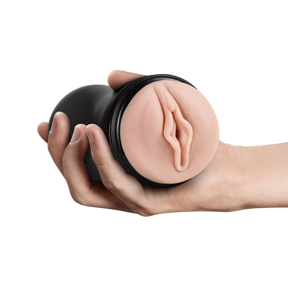 A hand holds the Blush Soft and Wet Pussy towards the camera. It's a realistic vulva with a pronounced clitoris. | Kinkly Shop