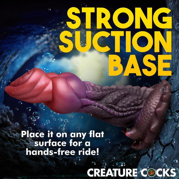 The Creature Cocks Deep Diver shown adhered to a cracked wall. Text on the image reads: Strong suction base. Place it on any flat surface for a hands-free ride. | Kinkly Shop