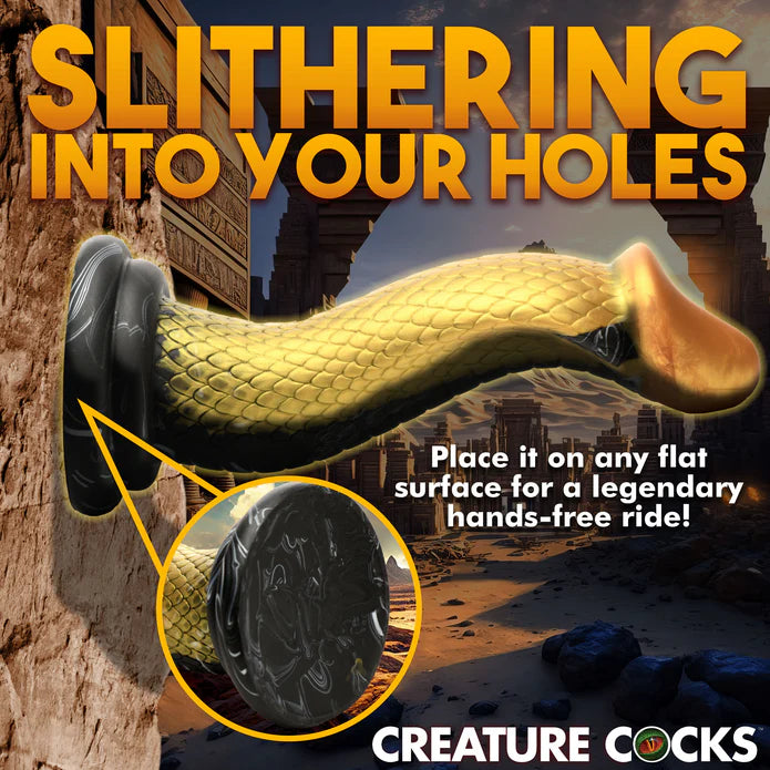 The Creature Cocks Golden Mamba shown suction cupped to a vertical stone wall. Text reads: Slitering into your holes. Place it on any flat surface for a legendary hands-free ride. | Kinkly Shop