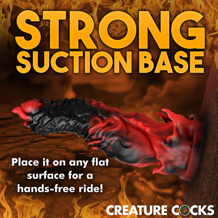The Creature Cocks Mephisto shown adhered to a hellish wall. Text on the image reads: Strong suction base. Place it on any flat surface for a hands-free ride. | Kinkly Shop