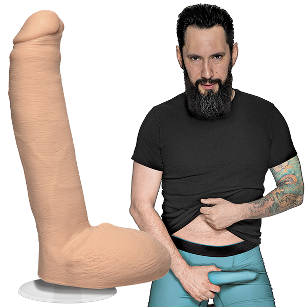 Tommy Pistol is looking into the camera while holding his erection that's in his boxer briefs. The Signature Cocks - Tommy Pistol dildo is shown next to the porn star, lifecast and modeled directly from him. | Kinkly Shop