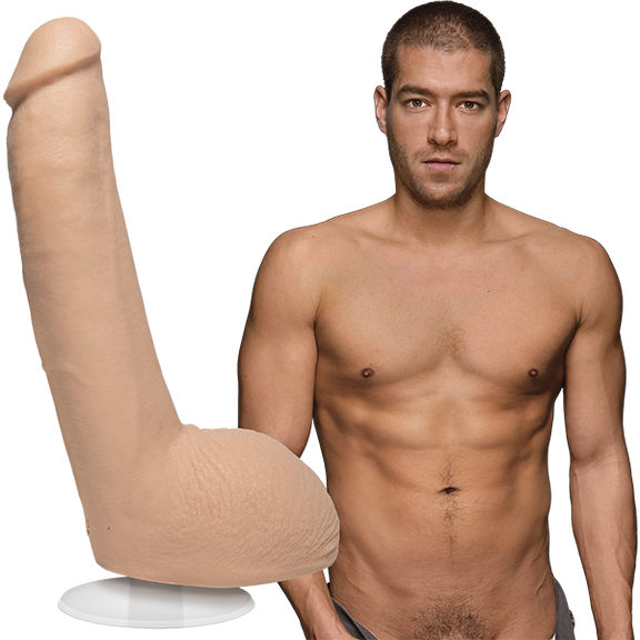 A naked Xander Corvus stares into the camera. The Signature Cocks - Xander Corvus dildo is shown next to Xander, which is modeled directly from the Xander's erect length. | Kinkly Shop