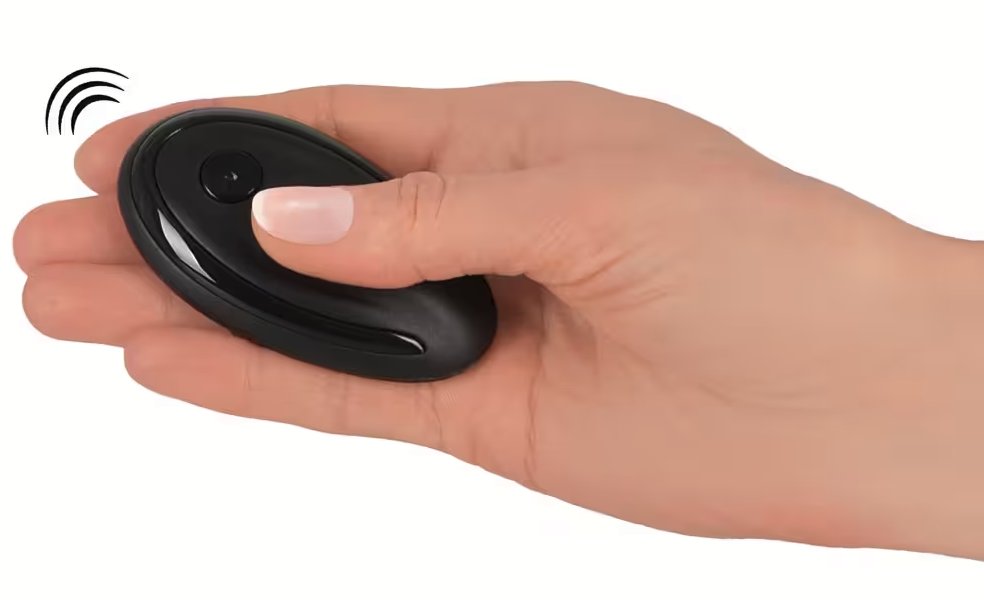 A hand holds the GoGasm Panty Vibrator remote and is pressing a button. The remote is oval-shaped and small, and it looks like it could hide in someone's closed fist easily. | Kinkly Shop