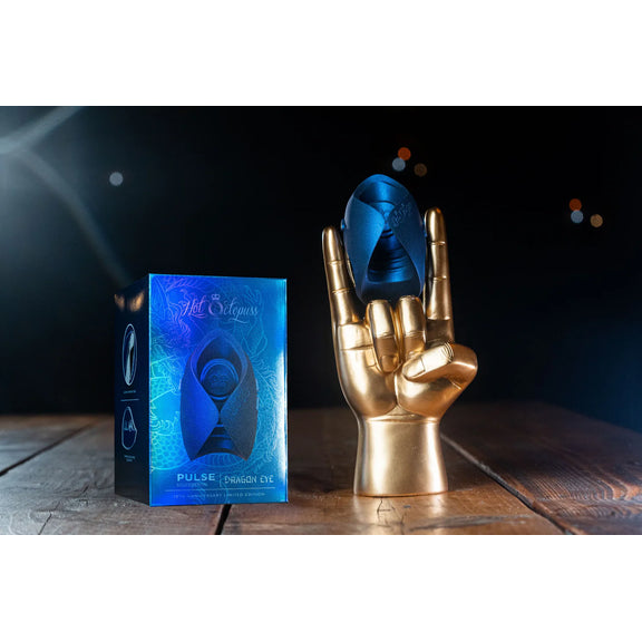 The Hot Octopuss Pulse Solo Essential - Limited Edition held up by a golden mannequin hand. The stroker is about as wide as three fingers in width. | Kinkly Shop