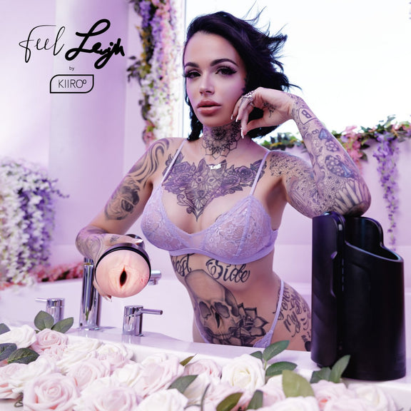 Leigh Raven is wearing purple lingerie while staring into the camera. She's holding the FeelStars FeelLeigh Stroker, facing it towards the camera, as she does. | Kinkly Shop