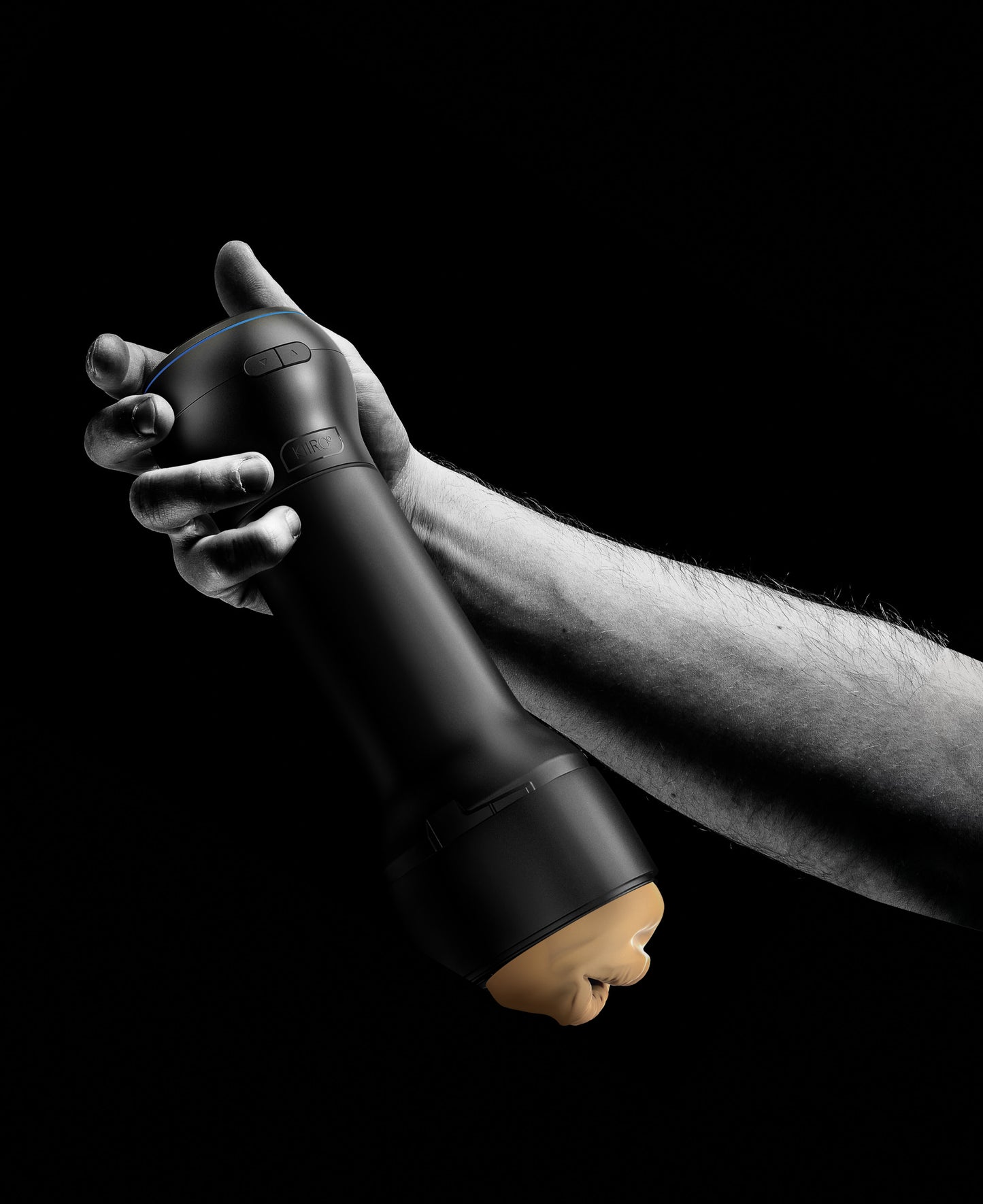 Black and white image shows a person holding the KIIROO Power Blow attached to a stroker. It adds a bit of length to the end of the stroker, but it also functions as a natural gripping point for using the stroker. | Kinkly Shop