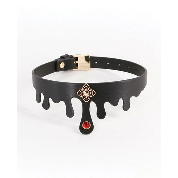 The NS Novelties Elvira Collar in front of a plain white background. It's made of a black faux leather with blood "droplets" built into the collar's shape. There's a gold charm and a gem on the center front of the collar. It has a color-matching gold buckle on the backside of the collar to adjust the circumference. | Kinkly Shop