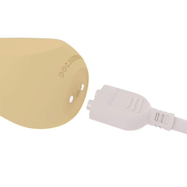 Close-up of the Ritual Sol shown next to the charging cable, about to be plugged in to the magnetic charger | Kinkly