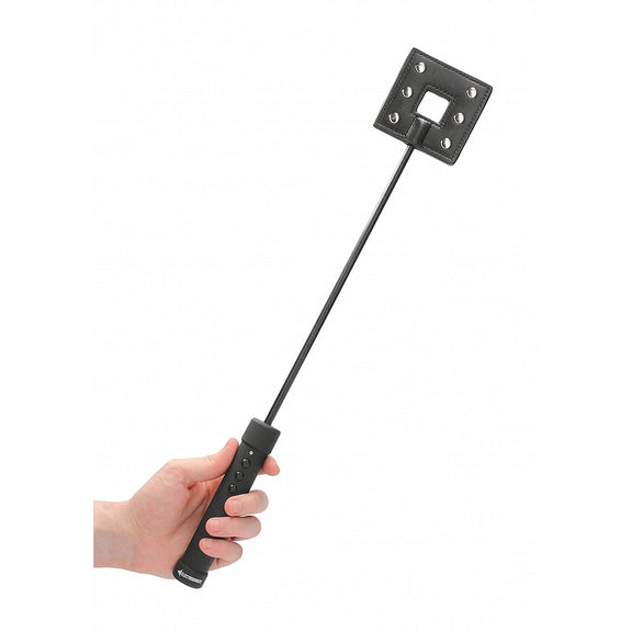 A hand holds the ElectroShock Rechargeable Crop. The tip of the crop is a square with metallic contact points. | Kinkly Shop