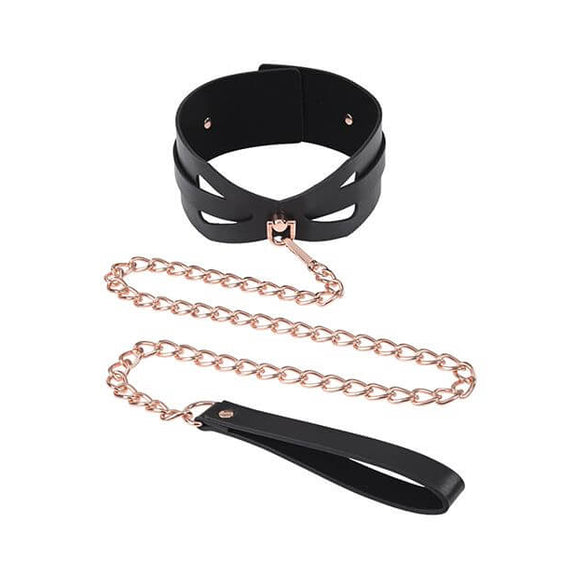 The Sportsheets Brat Collar and Leash fastened up in a circle like it would be worn. The leash is draped in front of the collar and attached to the D-ring on the front of the collar. The leash handle is closest to the camera, and it's a standard, simply loop that the hand or wrist can slide through to tug on the leash. | Kinkly Shop