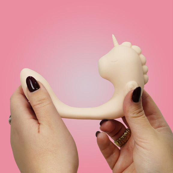 A person holds the two ends of the Unihorn C Horse, pulling them apart, showcasing how far apart the two sides can move. | Kinkly Shop