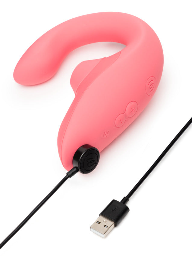 The Womanizer Blend plugged into its charger. Its charger has magnetic ports near the base of the handle for magnetic charging. | Kinkly