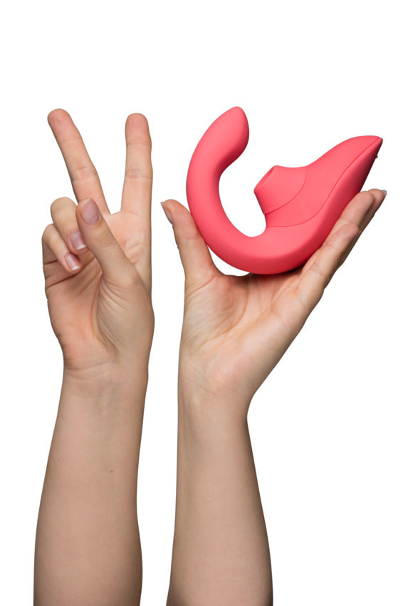 The Womanizer Blend is held up next to a hand that has two fingers up. This showcases the two types of stimulation the Blend offers. | Kinkly