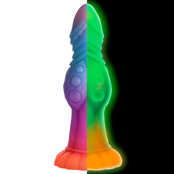 Two images of the Creature Cocks Galactic Cock. On the left, the image shows what the dildo looks in daylight. On the right, it shows what the dildo looks like in glow in the dark. | Kinkly Shop