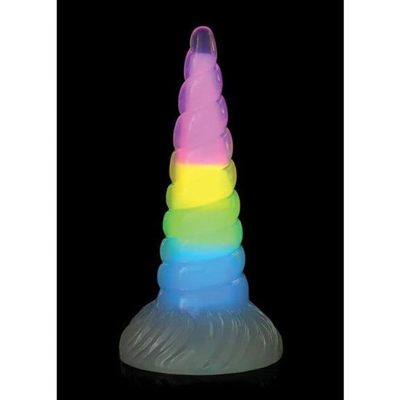 The Creature Cocks Uni Glow in front of a plain black background. The Glow-in-the-Dark pigment is glowing strongly, showcasing a pastel rainbow color throughout the entire interior length of the dildo. | Kinkly Shop