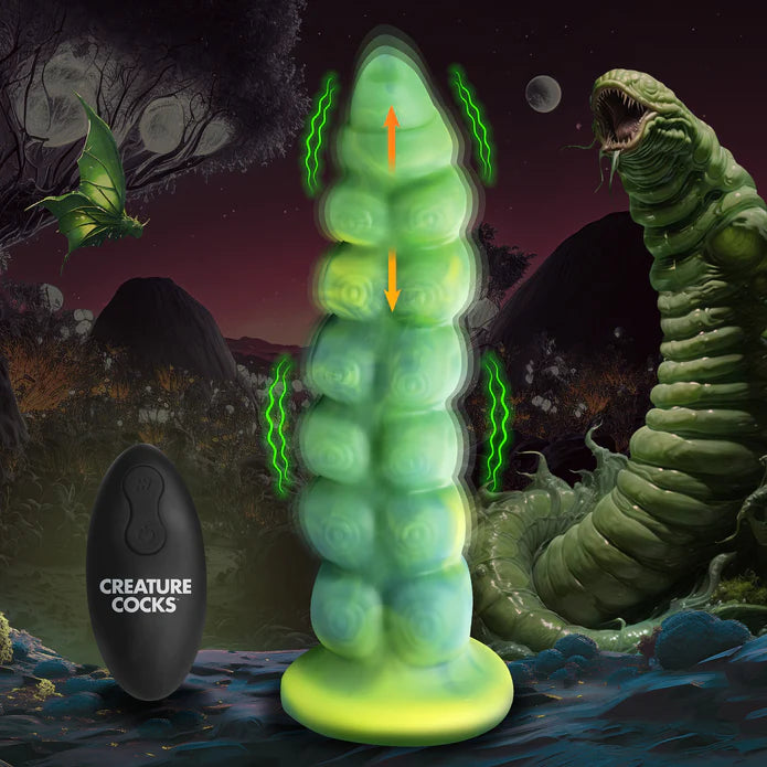 The Creature Cocks Squirmer Vibrating Thruster with Remote Control shown in front of a monster worm creature. Illustrations on the dildo show it vibrating and thrusting. | Kinkly Shop