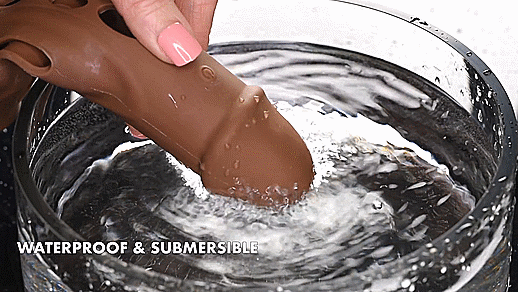 GIF showcases a person holding the tip of the Evolved Big Shaft Extender in a clear bowl full of water. The water has a pretty big spray as the toy's vibrations vibrate the surface of the water. | Kinkly Shop