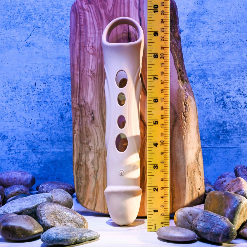 The Evolved Big Shaft Extender laying out next to a ruler. The Evolved Big Shaft Extender is about 9.5" in total length, with the testicle strap included in the length. | Kinkly Shop