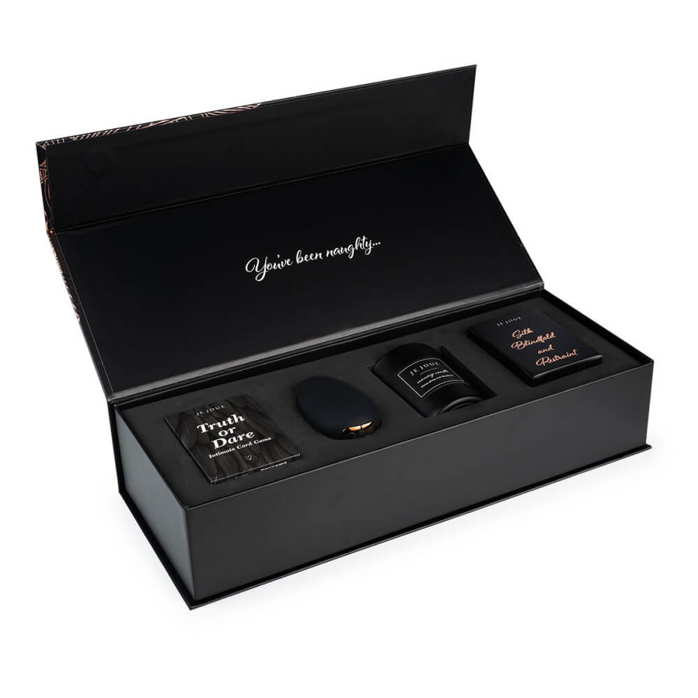 All of the items within the Je Joue Naughty Collection box shown inside of their box with the box's lid open. The box looks very sturdy (and in a sultry, black color) with the text "You've been naughty..." printed on the top of the gift box. | Kinkly Shop