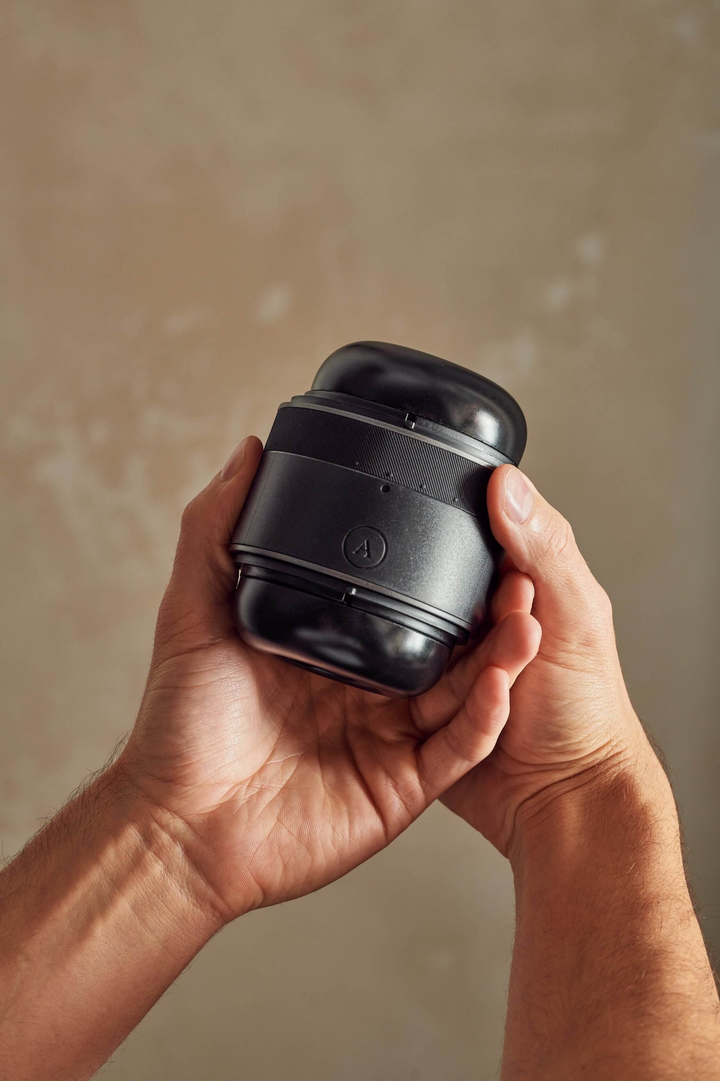Two hands grasp the Arcwave Voy. One hand is grasping the shaft of the Arcwave Voy while the opposing hand grasps the tightness ring on the stroker to adjust the tightness. | Kinkly Shop